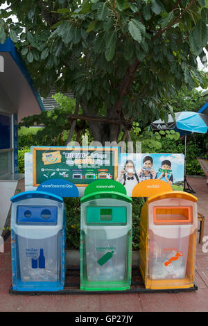 Con codifica a colori degli scomparti di riciclaggio in corrispondenza di un bordo strada area riposo in Thailandia, sud-est asiatico Foto Stock
