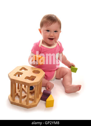 Baby girl giocando con forma di legno intaglio sorter Foto Stock