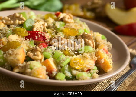 La quinoa Insalata Waldorf con Apple, sedano, giallo uvetta e noce servita su piastra, ingredienti nel retro Foto Stock