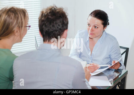 Consulente o agente immobiliare lavora con un paio di clienti in ufficio Foto Stock
