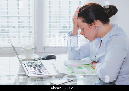 Stanco donna d'affari con computer in ufficio, lo stress e i problemi, sensazione di rammarico e colpevole Foto Stock