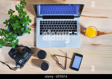 Fotografo workplace, ingranaggio, vista dall'alto della scrivania con computer portatile, fotocamera, lenti e lo smartphone Foto Stock
