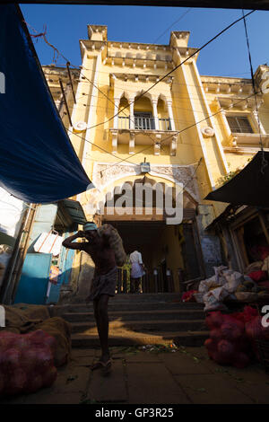 Carico di testa i lavoratori di scarico sacchi veget nel mercato Devaraja a Mysore, India. Carico di testa i lavoratori sono organizzati di forza lavoro. Foto Stock