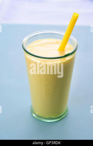 Mango lassi in vetro con paglia. Frullato di mango fatta con mango e yogurt, yogurt. Messa a fuoco selettiva. Angolo di visione. Foto Stock