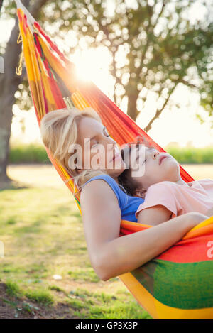 Madre e figlio napping insieme in amaca Foto Stock