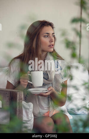 Donna gustando una bevanda calda all'aperto Foto Stock