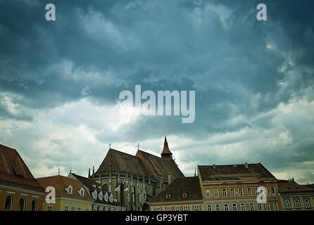 Immagine delle vecchie case medievali al di sopra di un cielo nuvoloso nel centro storico della città di Brasov. Foto Stock