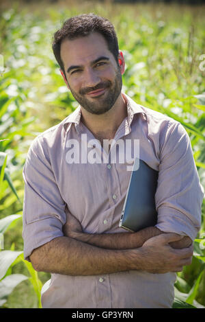 Agricoltore in piedi in cornfield Foto Stock