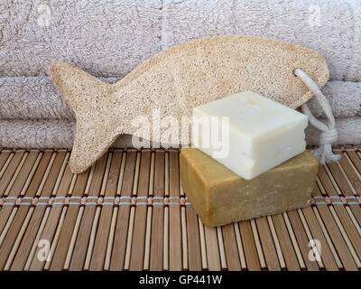 Sapone casalingo bar, loofah spugna in forma di pesce e asciugamani in spugna sul tappetino di bambù Foto Stock