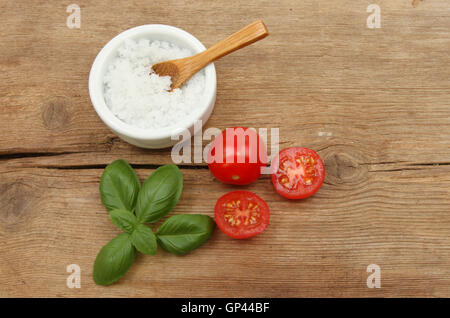 Seasalt pomodori e basilico sul legno rustico Foto Stock