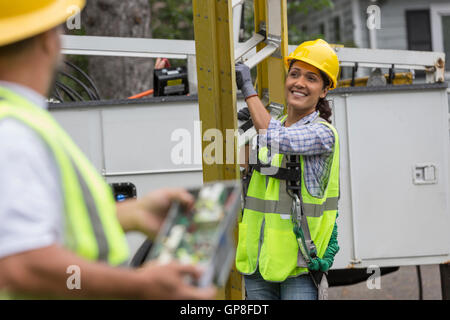 I lavoratori di utilità guardando il lavoro di linea sul sito Foto Stock