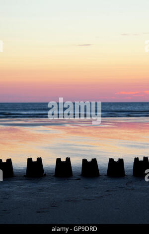 Linea di silhouette Sandcastles al sorgere del sole su una spiaggia. Northumberland, Inghilterra Foto Stock