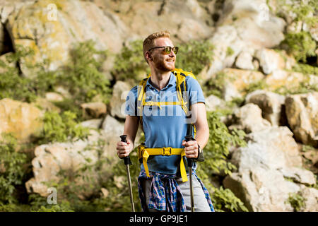 Caucasica modello maschio con zaino escursionismo sulla giornata di sole Foto Stock