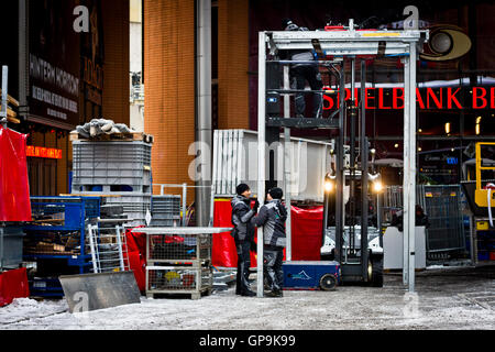 Uomo al lavoro su un pre-Berlinale sito in costruzione al di fuori della Potsdamer Platz Theater di Berlino, Germania. Foto Stock