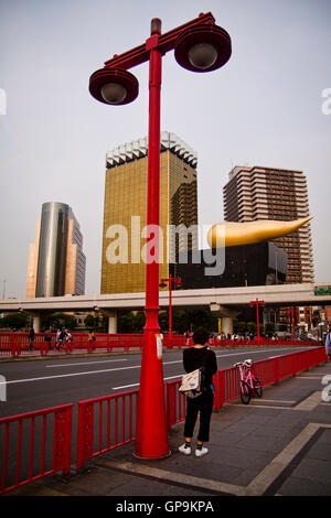 Un uomo sul ponte da Asahi Breweries HQ in Tokyo, Giappone Foto Stock