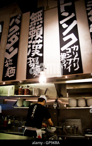 Uno chef prepara il cibo in un ristorante di peperoncino ramen a Tokyo, Giappone Foto Stock