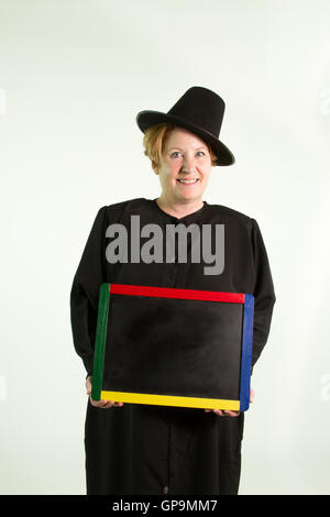 Donna matura vestita di nero pellegrino accappatoio e hat holding lavagna. Foto Stock