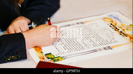 Tradizionale Matrimonio ebraico, la firma di accordi prematrimoniali ketubah. Il matrimonio ebraico di contratto. Foto Stock