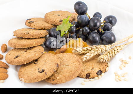 I cookie di integrale con uva e mandorle su bianco Foto Stock