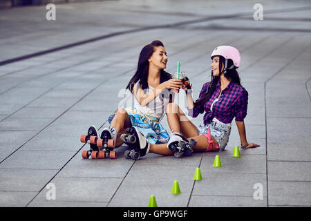 Due attraenti adolescente amici femmina hanno riposo dopo le attività all'aperto Foto Stock