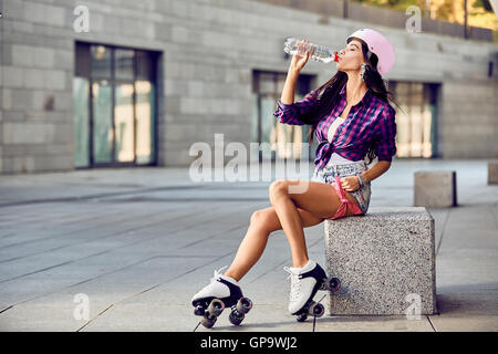 Hipster ragazza bere acqua e riposo dopo il tempo attivo Foto Stock