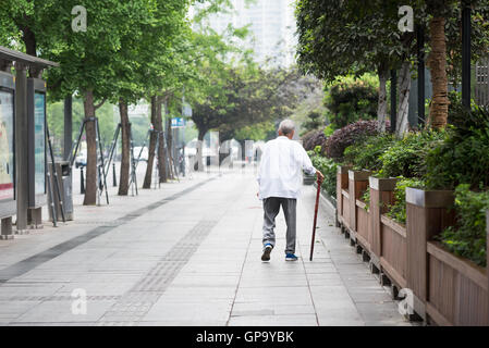 Chengdu, nella provincia di Sichuan, in Cina - Febbraio 5, 2016: il vecchio uomo a camminare da soli con una canna in strada Foto Stock