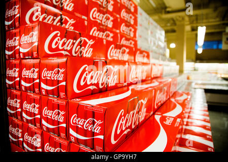 Le lattine di coca cola casi impilati in un display a un negozio di alimentari. Foto Stock