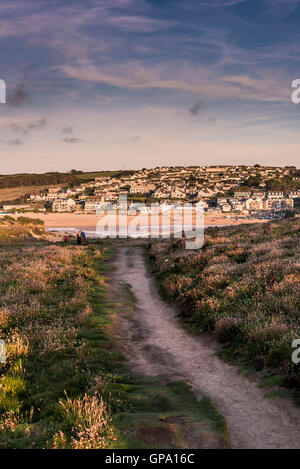 Un sentiero sul Porth Island con proprietà costiere in distanza. Newquay. La Cornovaglia. Foto Stock