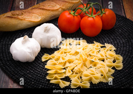 Bowtie pasta con vite pomodori maturi e aglio Foto Stock