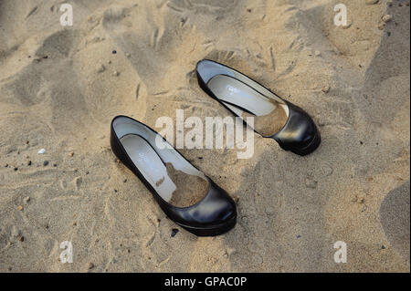 Coppia di scarpe donna mentre si cammina su una spiaggia di sabbia. All'interno di calzature pour la sabbia. Foto Stock