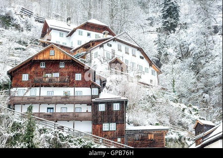 Tradizionali case di legno sul pendio di una collina nelle montagne delle Alpi, Hallstatt, Austria Foto Stock