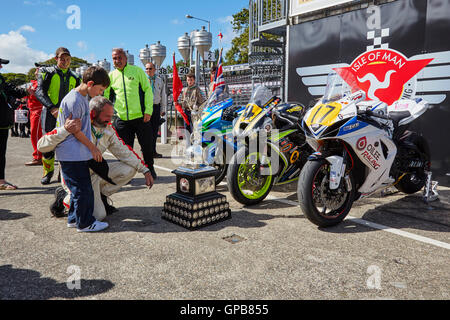 Steve Weedon mostra Finn il trofeo che il suo fratellastro Tom ha appena uno al 2016 Grand Prix Gare Foto Stock