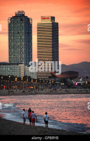 Barcellona/Spagna - 20 giugno 2016: la gente camminare sulla spiaggia di Barceloneta al crepuscolo e, sullo sfondo, Luxury Hotel Arts grattacielo Foto Stock