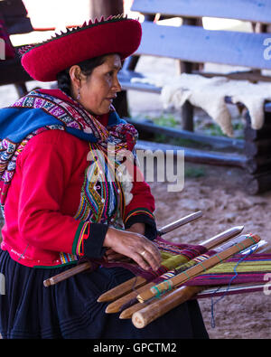 Chinchero Perù : 18 maggio : Nativi Cusquena donna vestita in tradizionali abiti colorati spiegando tradizionali metodi di tessitura. Foto Stock