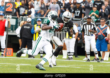 Set 25, 2011; Oakland, CA, Stati Uniti d'America; New York getti running back LaDainian Tomlinson (21) giunchi passato Oakland Raiders linebacker Quentin Groves (52) per segnare un touchdown durante il secondo trimestre a O.co Coliseum. Oakland sconfitto New York 34-24. Foto Stock