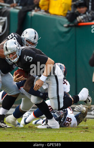 Novembre 6, 2011; Oakland, CA, Stati Uniti d'America; Oakland Raiders quarterback carson palmer (3) è saccheggiata da Denver Broncos difensivo fine elvis dumervil (retro) durante il primo trimestre a o.co Coliseum. Foto Stock