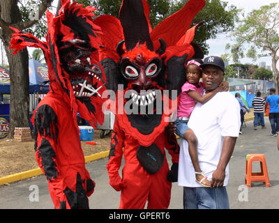 Città di Panama - 19 febbraio 2012: il Bambino di scattare una foto con la Red revils, le tipiche maschere di carnevale in Panama Foto Stock