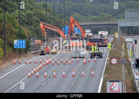 Lavoratori di demolizione di rimuovere la restante struttura del danneggiamento di una passerella oltre l'autostrada M20 nel Kent, che è stata chiusa in entrambe le direzioni per consentire le autostrade in Inghilterra per svolgere il lavoro. Foto Stock