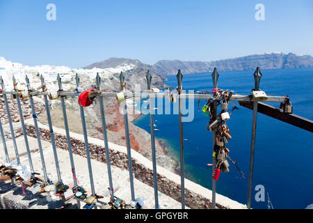 Multi-colore di amante di lucchetti adornano un set di ringhiere nella cittadina di Oia, sulla bellissima e romantica isola greca di Santorini. Foto Stock