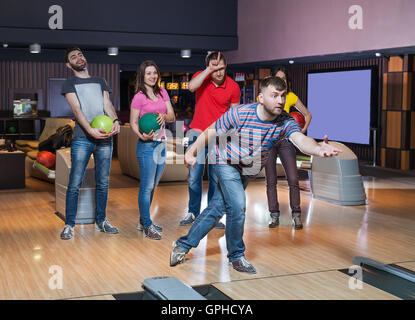 Amici divertendosi in bowling Foto Stock