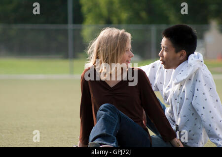 Teens seduto in un parco avente una conversazione. Foto Stock