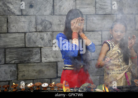 Kathmandu, Nepal. 4 Sep, 2016. Le donne nepalesi offrendo preghiere nelle celebrazioni del Teej festival nel Tempio Pashupathinath premessa a Kathmandu, Nepal, domenica 4 settembre, 16. Le donne sposate e non venite a festeggiare il loro rapido dal culto offerta al Signore Shiva per la felicità coniugale e il benessere delle loro marito da pregare e cantare e ballare. © Skanda Gautam/ZUMA filo/Alamy Live News Foto Stock