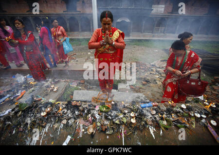 Kathmandu, Nepal. 4 Sep, 2016. Le donne nepalesi offrendo preghiere nelle celebrazioni del Teej festival nel Tempio Pashupathinath premessa a Kathmandu, Nepal, domenica 4 settembre, 16. Le donne sposate e non venite a festeggiare il loro rapido dal culto offerta al Signore Shiva per la felicità coniugale e il benessere delle loro marito da pregare e cantare e ballare. © Skanda Gautam/ZUMA filo/Alamy Live News Foto Stock