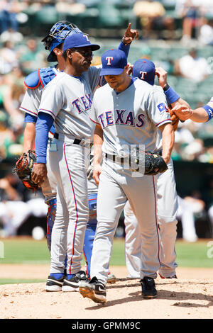 Agosto 7, 2010; Oakland, CA, Stati Uniti d'America; Rangers di Texas a partire lanciatore ricca harden (anteriore) è dispensato dal manager ron washington (sinistra) durante il terzo inning contro Oakland atletica di Oakland-alameda county Coliseum. Foto Stock