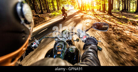 I driver del motociclo equitazione sulla autostrada nella splendida luce del tramonto. Colpo da pillion vista driver Foto Stock