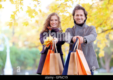 Coppia felice con le borse della spesa in autunno park Foto Stock