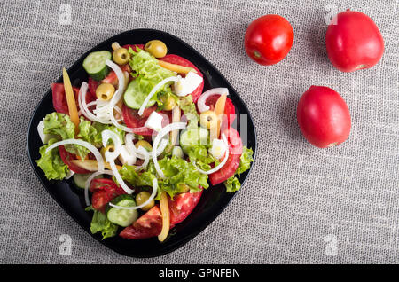 Vista dall'alto di una piccola ciotola di insalata fatto naturale verdure crude e formaggio feta closeup Foto Stock
