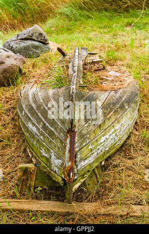 Molto vecchio marciume barca giacente sulla terra asciutta sprecando lontano. La natura si sta lentamente recuperando il materiale nel recipiente abbandonati. Foto Stock