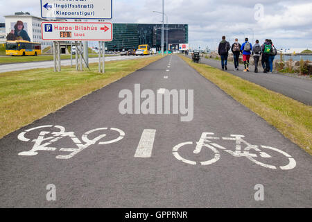 Pista ciclabile e pedonale con footway bicicletta segni dipinti sulla superficie di asfalto lungo il lungomare. Reykjavik, Islanda Foto Stock