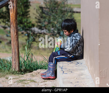 Chinchero Perù : 18 maggio : Giovane ragazzo andina con un grande cartone di succo di frutta. Il 18 maggio 2016, Chinchero Perù. Foto Stock